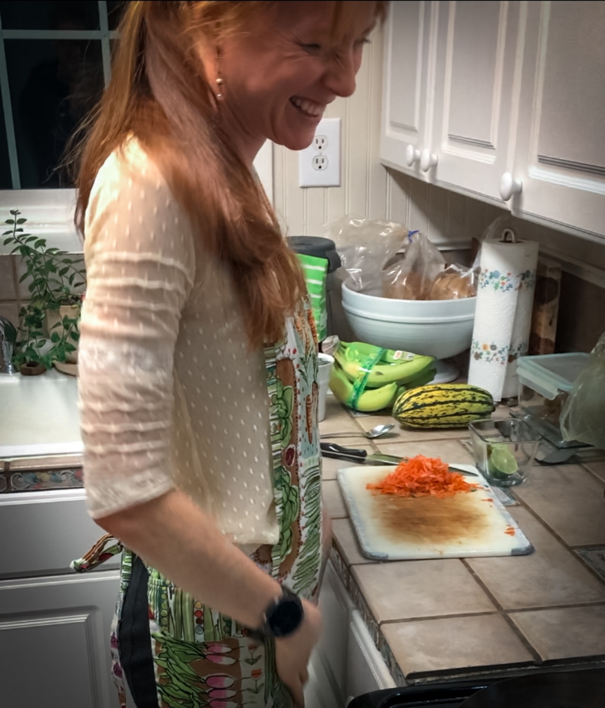 woman feeling good, with balanced gut health, standing in kitchen